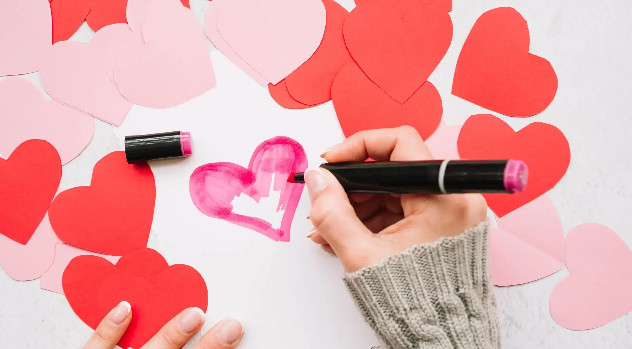 Une femme dessine un joli coeur pour la saint valentin